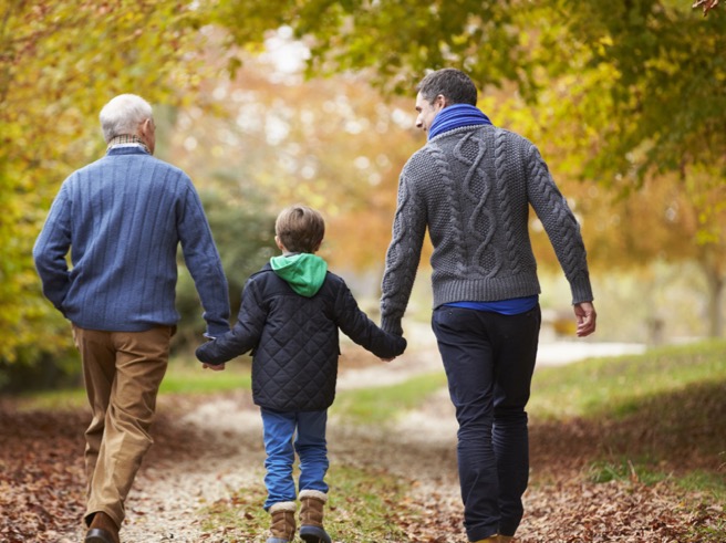 3 generations walking through the woods reflecting a family legacy